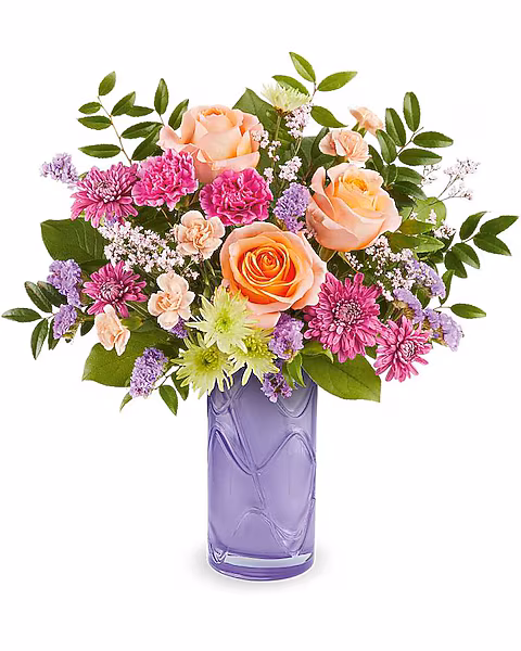 Celebrate her sweetest moments with the Pretty Daydream Bouquet, a dreamy mix of soft, vibrant blooms beautifully arranged in the Pretty Daydream Vase-a charming keepsake she'll enjoy long after Mother's Day.

The Pretty Daydream Bouquet features peach roses, fuchsia carnations, miniature peach carnations, green and purple cushion spray chrysanthemums, purple sinuata statice, and pink limonium, accented with huckleberry and salal, delivered in the Pretty Daydream Vase.